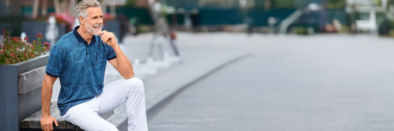 Mann mit blauem Shirt und weisser Hose