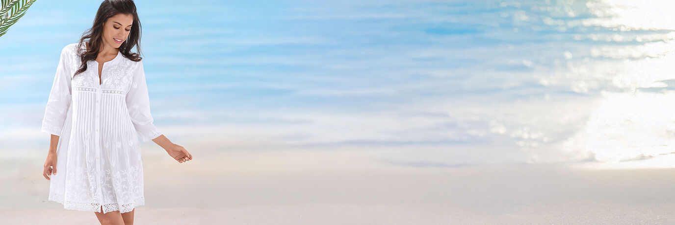 Frau in weissem Kleid am Strand