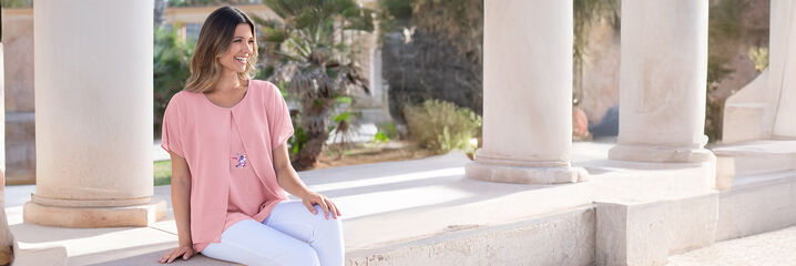 Dame in rosa Bluse und weisser Hose