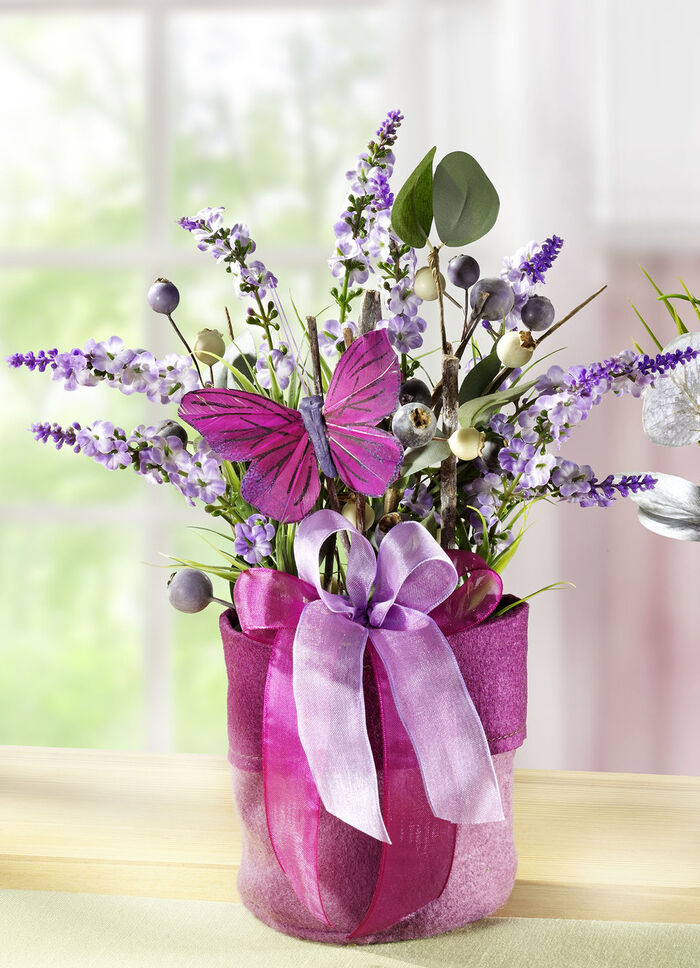 Frühlingsgesteck mit Blumen und Gräser im Filzbeutel LILA